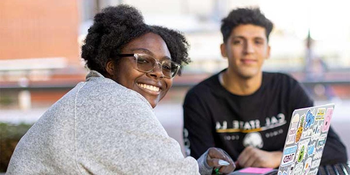 Two Students at table around computer